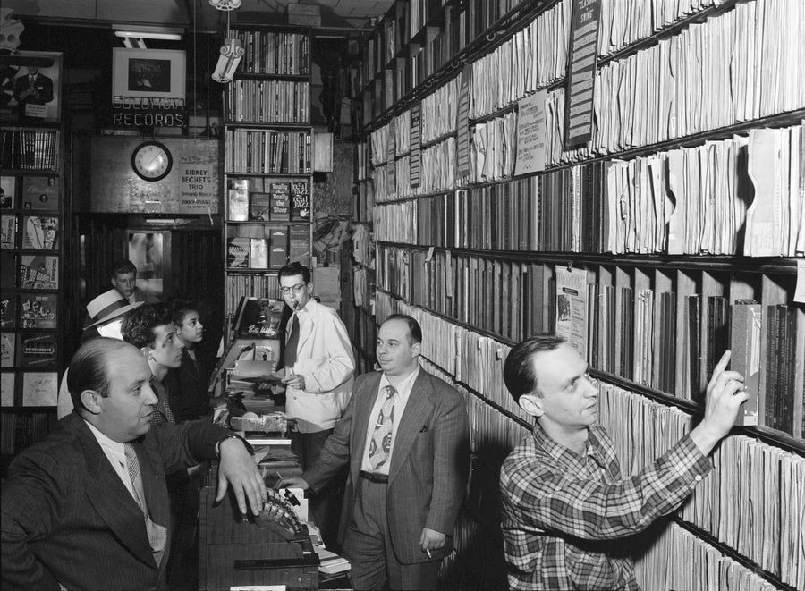 Customers and staff among shelves of records at the Commodore Record Shop in New York, circa August 1947.